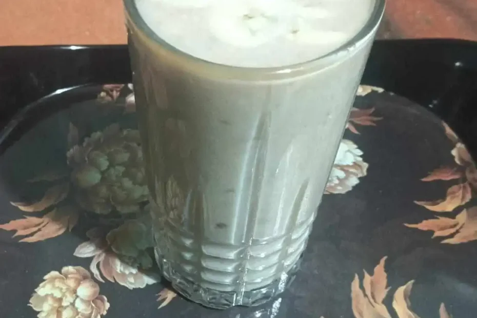 Creamy peanut butter banana smoothie topped with fresh banana slices in a glass