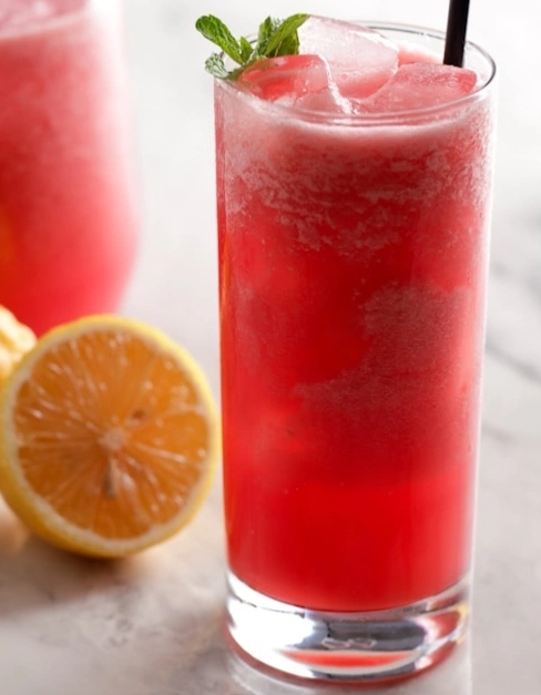 Refreshing watermelon mint cooler served in a tall glass with ice cubes, fresh mint leaves, and a lemon slice, perfect for hydration and cooling down on hot summer days.